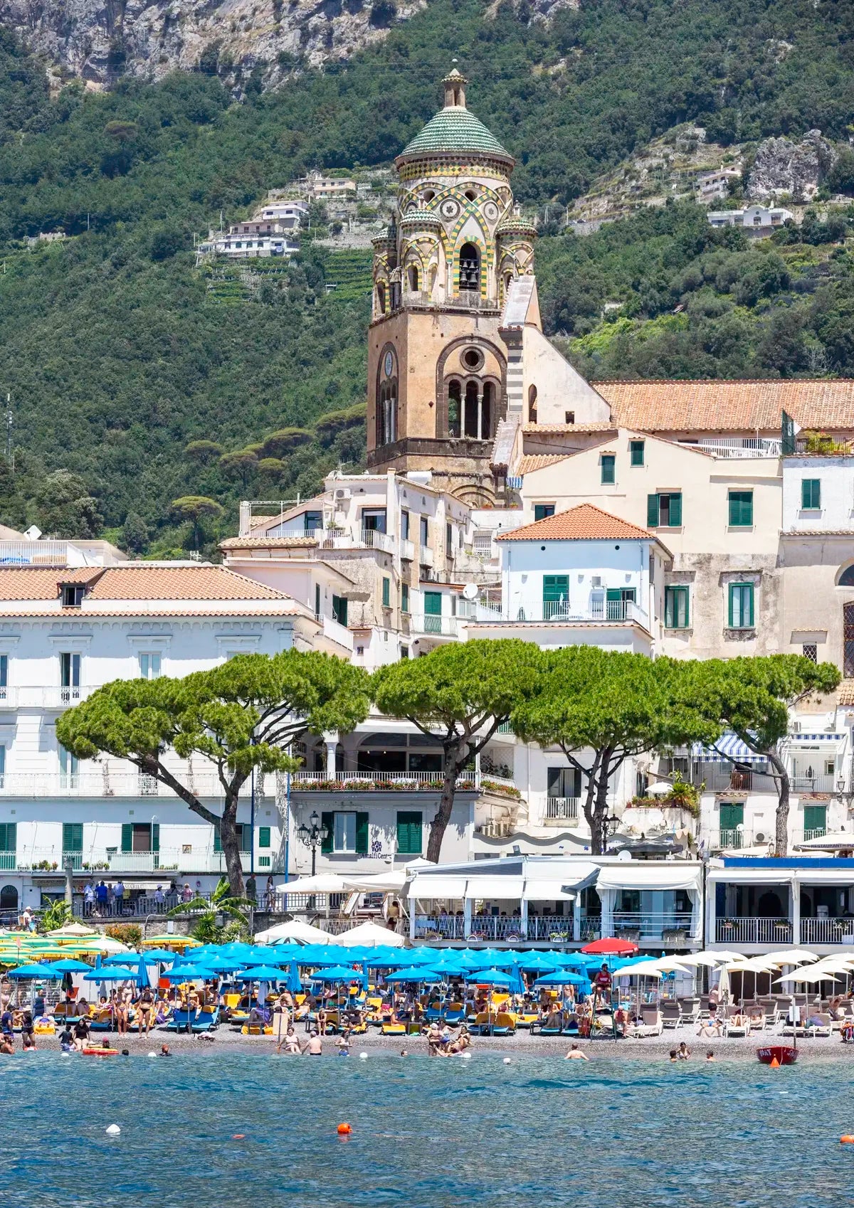 Coastal cityscape with a prominent church and mountainous background