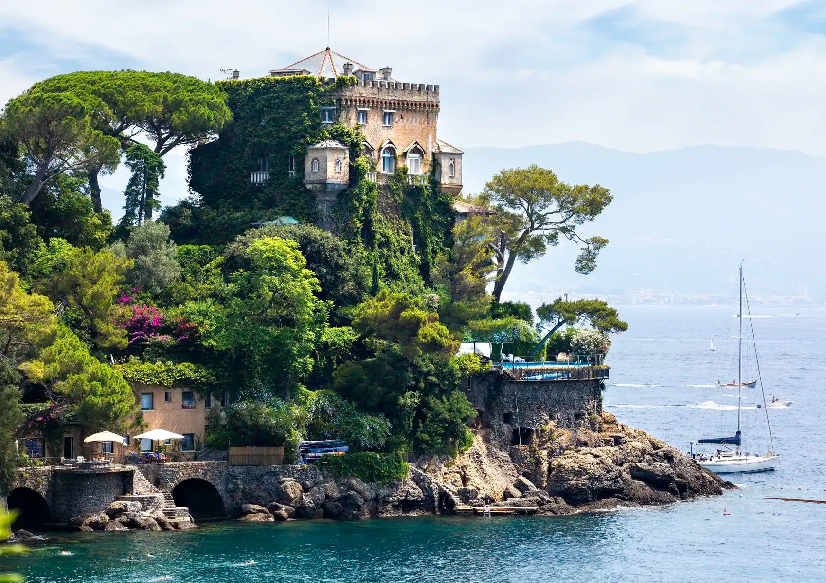 Castle on a rocky island with sailboats in the background