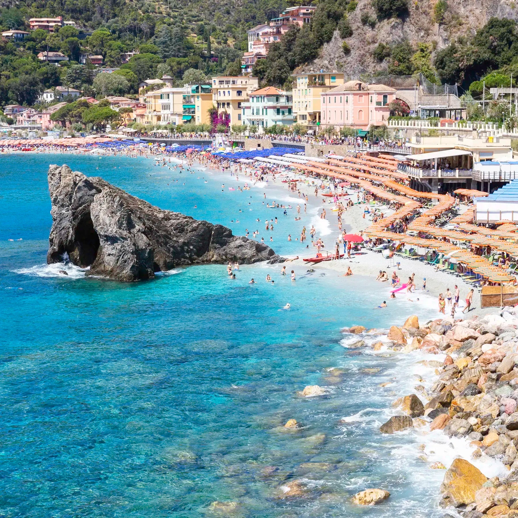 Beach scene with rocky outcrop and buildings in the background