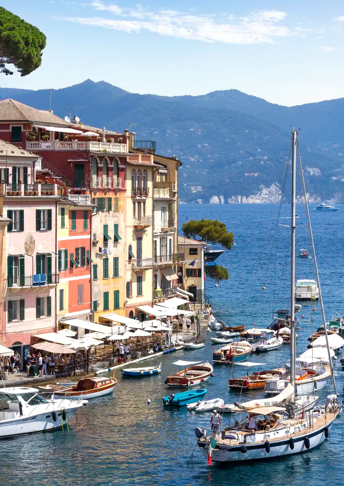 Portofino Harbour scene with boats and buildings by a mountainous landscape
