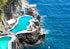 Two pools built into a rocky cliffside with ocean view