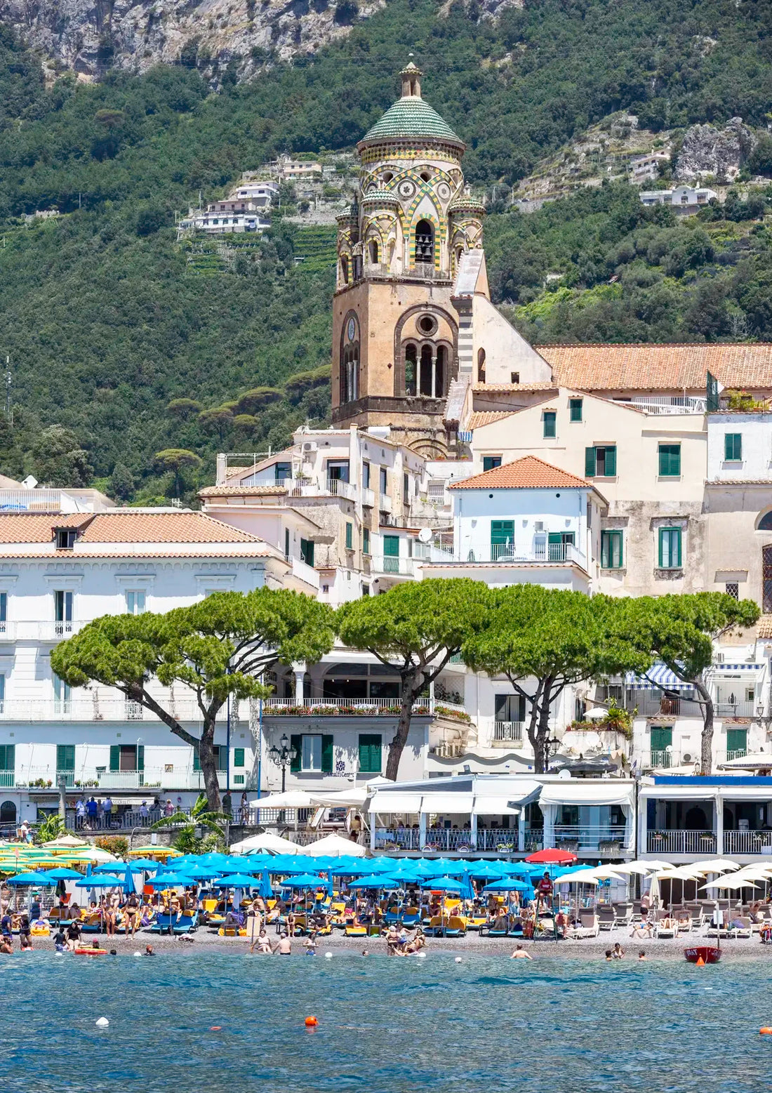 Coastal cityscape with a prominent church and mountainous background