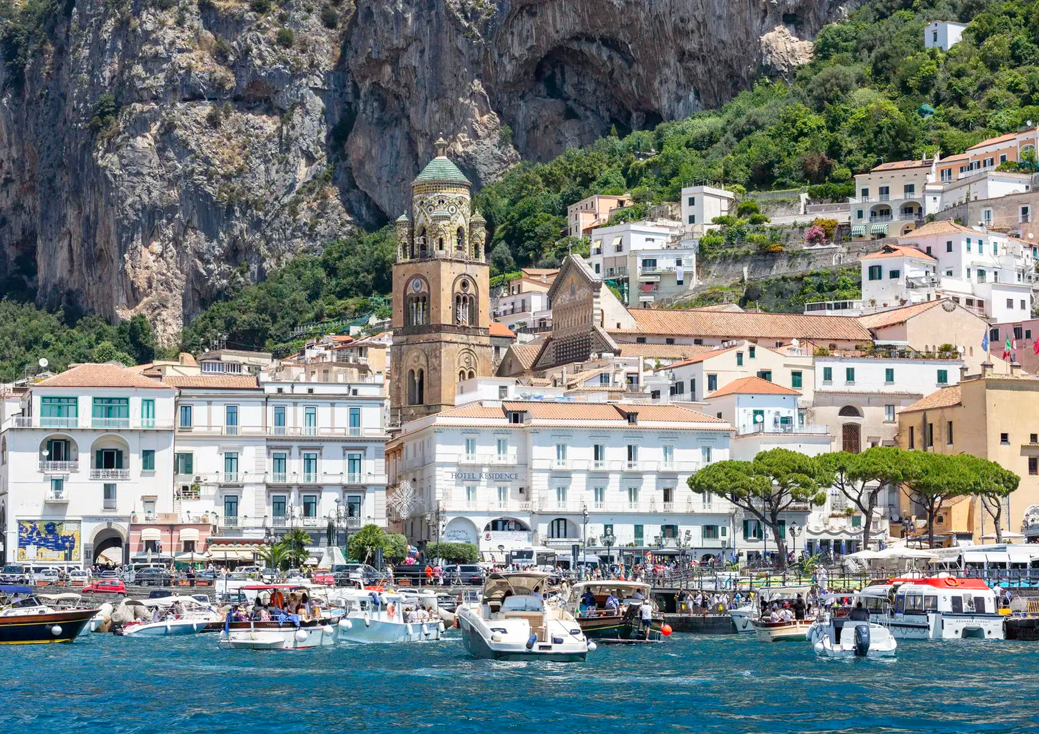 Village by the sea with boats and a mountainous background