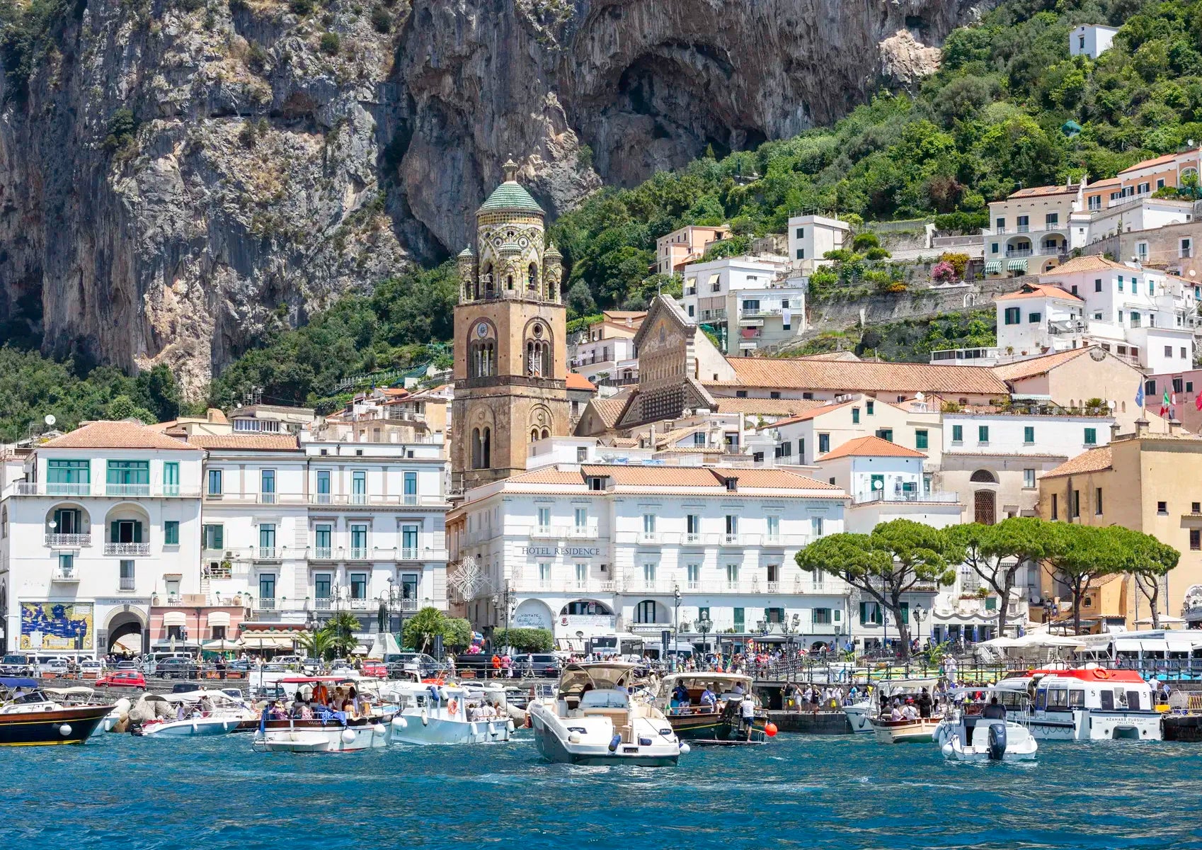 Village by the sea with boats and a mountainous background