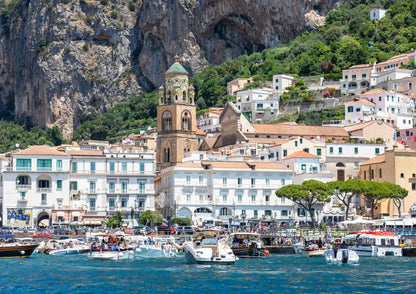 Village by the sea with boats and a mountainous background