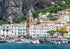 Village by the sea with boats and a mountainous background