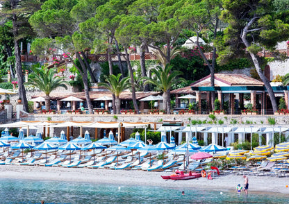 Beachside resort with umbrellas, lounge chairs, and a view of the water.