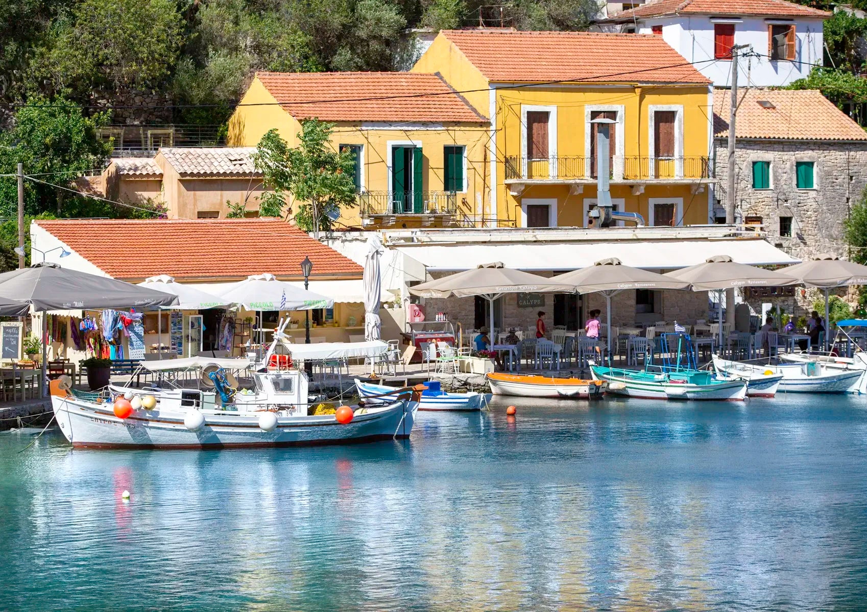 Beautiful Kioni harbour scene with boats and colorful buildings in a coastal town.