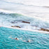 Two people swimming in the Bondi iceberg ocean pool with ocean waves in the background