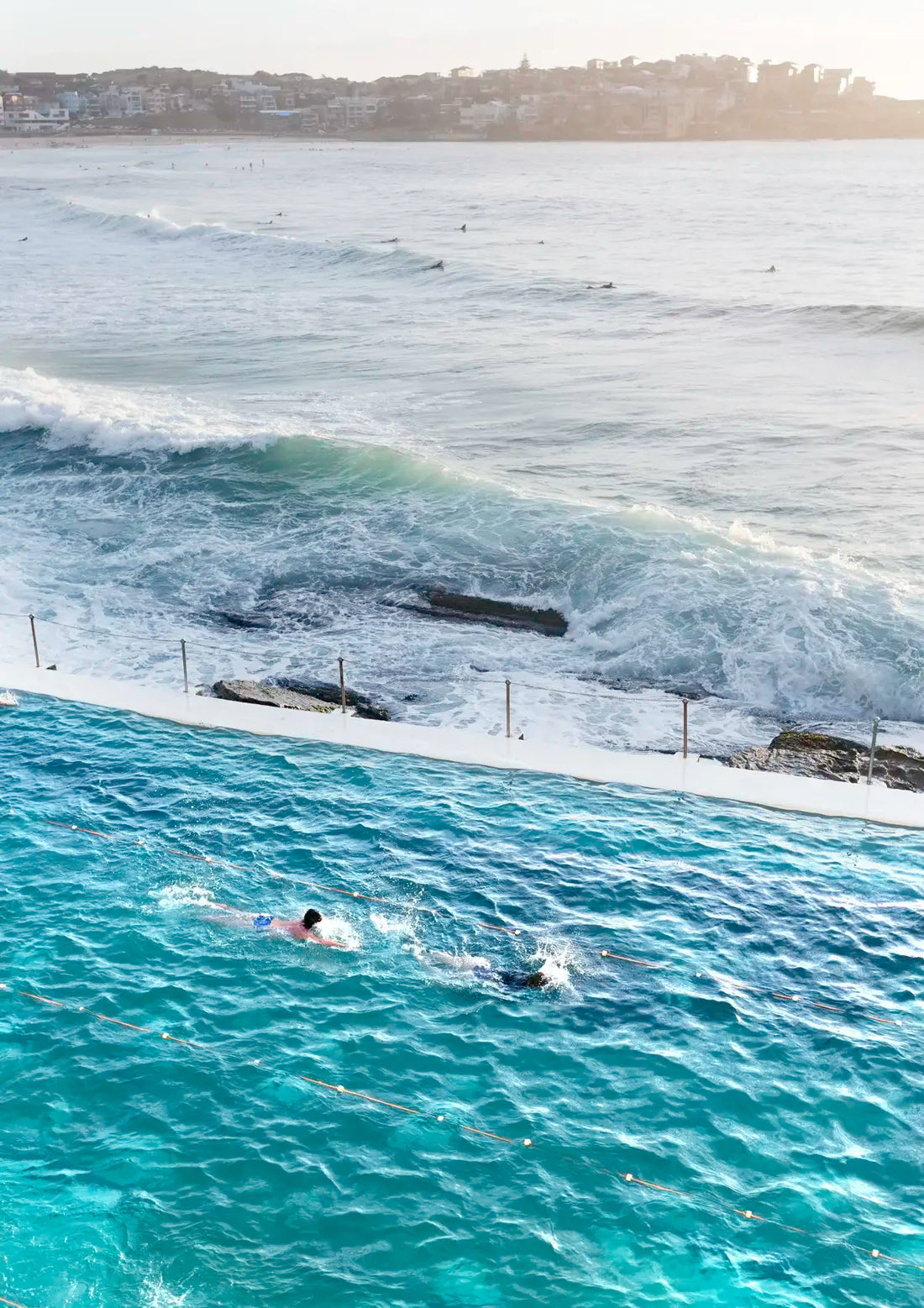 Person swimming in an ocean pool with ocean waves in the background