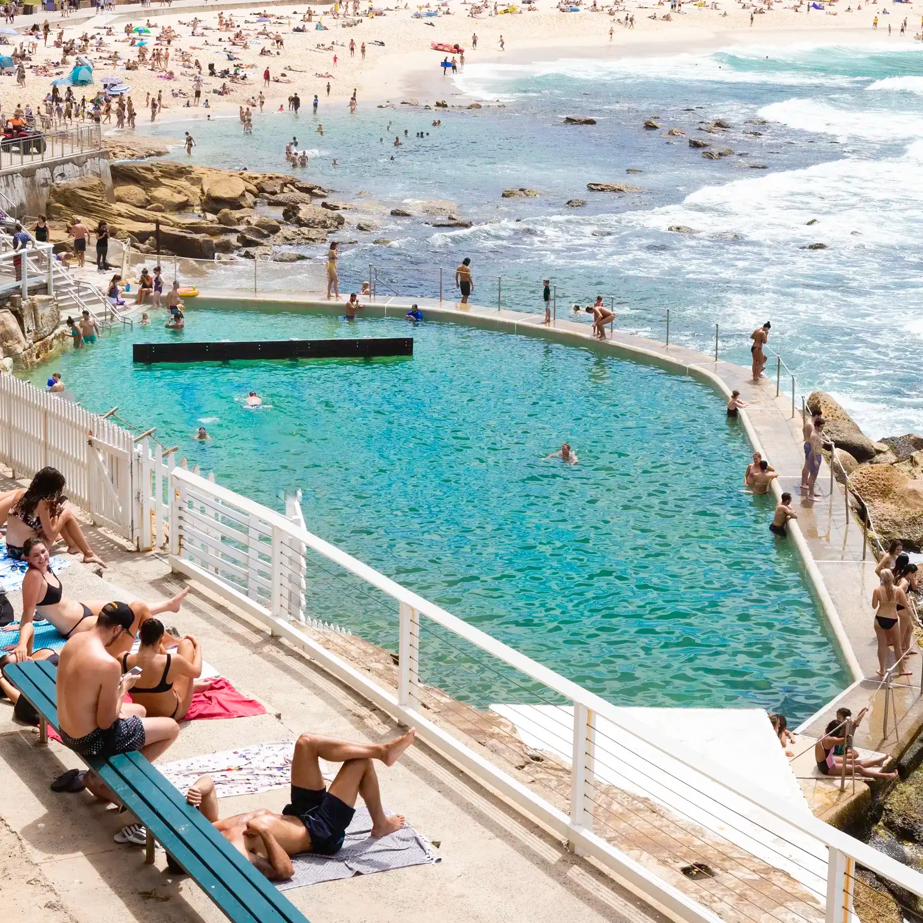 People enjoying a pool at the beach with ocean view