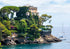 Castle on a rocky island with sailboats in the background