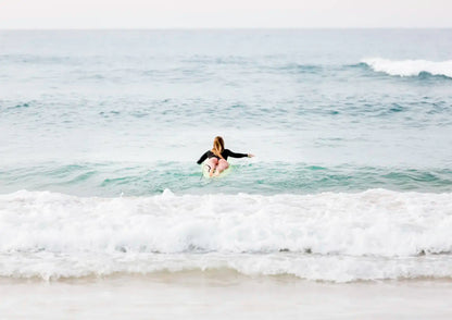 Female surfer paddling out to surf