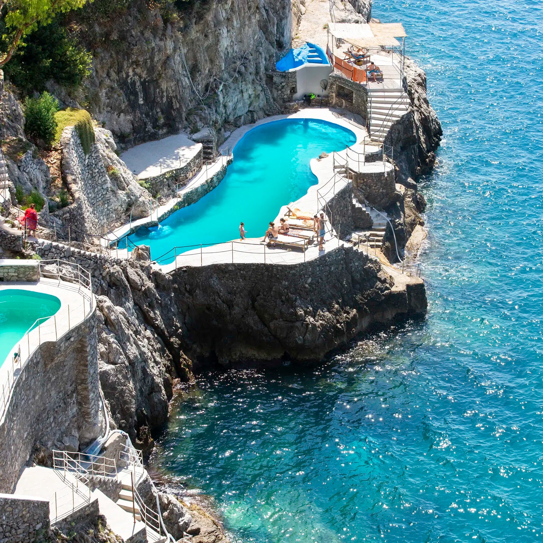 Swimming pool built into a rocky cliffside with ocean view