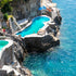 Swimming pool built into a rocky cliffside with ocean view