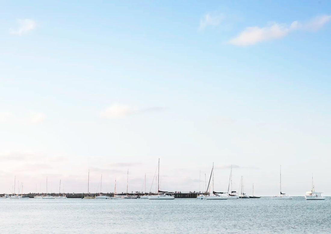 Sailing boats on a calm body of water with a clear sky