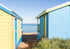 Two colorful beach huts on a sandy area with ocean view