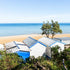 Beach huts on a sandy beach with ocean in the background