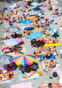 People sunbathing on a crowded beach with colorful umbrellas and towels.