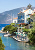 Coastal scene with houses, a dock, and people enjoying the water.