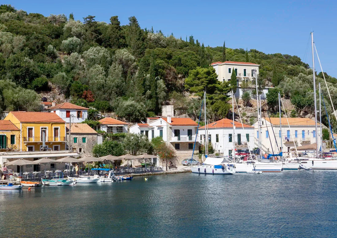 Kioni Harbour scene with boats and buildings on a hillside under a clear blue sky.
