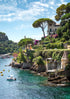 Coastal scene with houses, trees, and a boat on a clear day in Portofino.