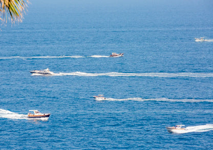 Multiple boats on a body of water with a clear sky