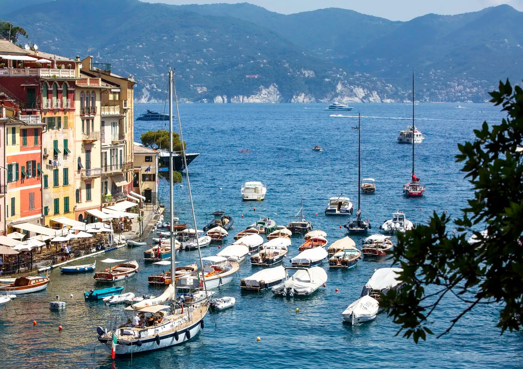 Marina with boats and buildings by a mountainous coastline