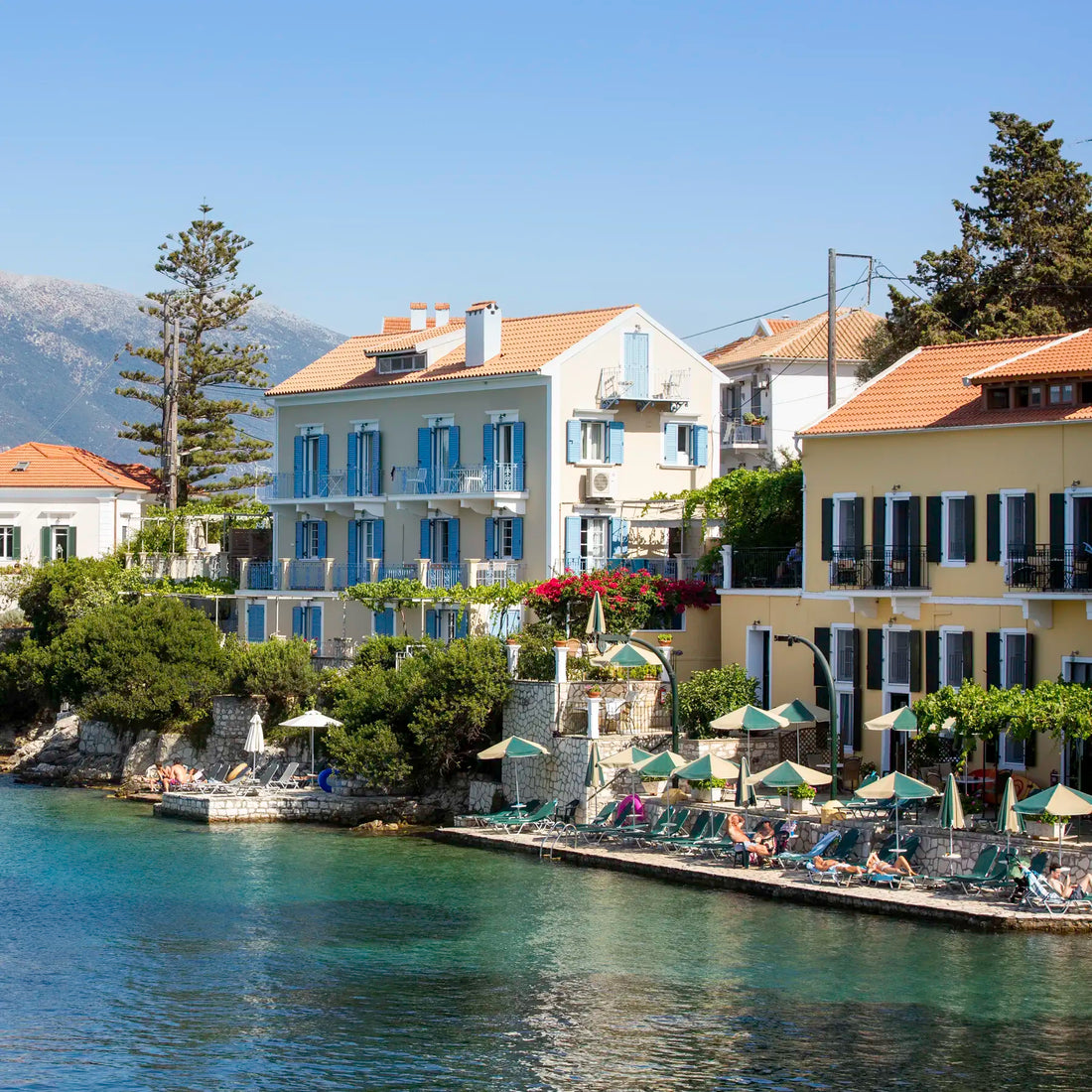 Coastal town with buildings by the water, mountains in the background