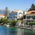 Coastal town with buildings by the water, mountains in the background
