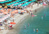 Beach scene with people, umbrellas, and water activities